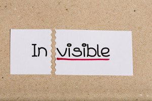 Two pieces of white paper with the word invisible turned into visible